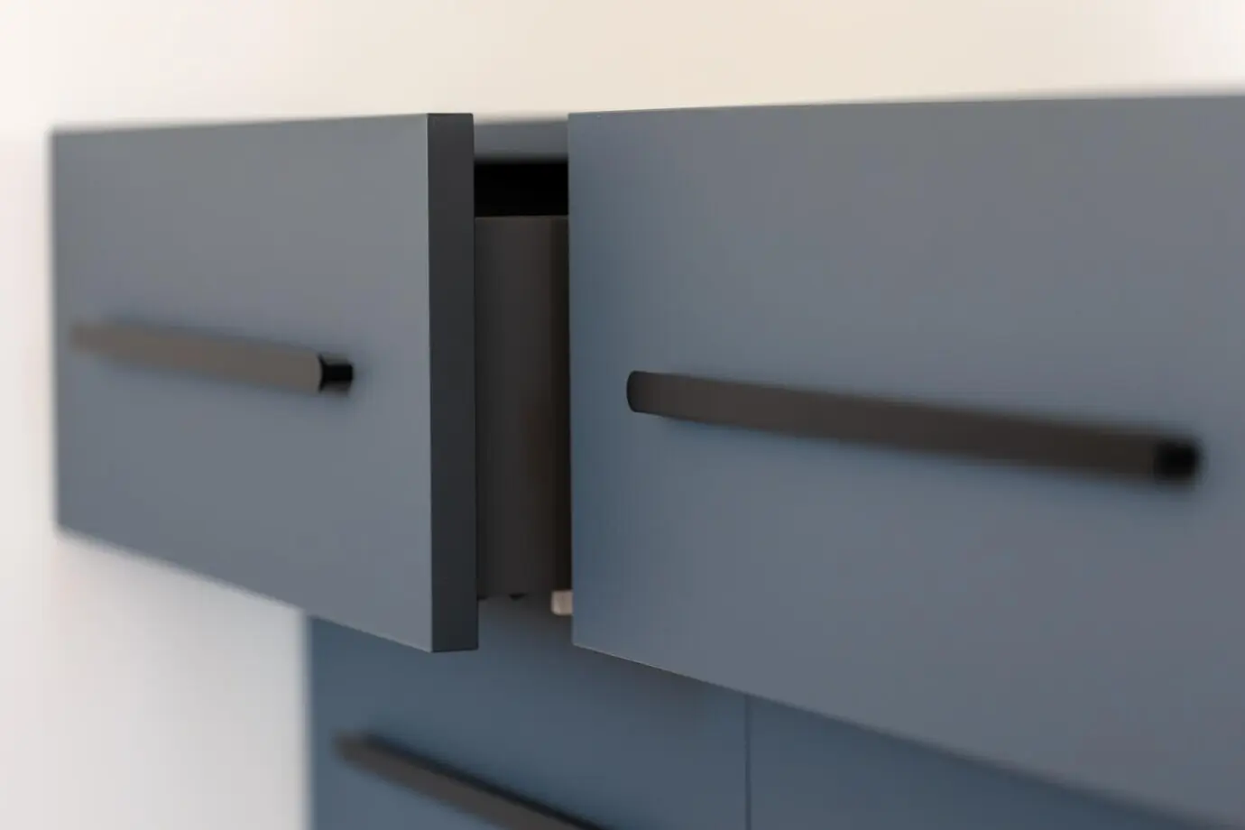 Cajones flotantes con tiradores de barra negros, pizarra mate.